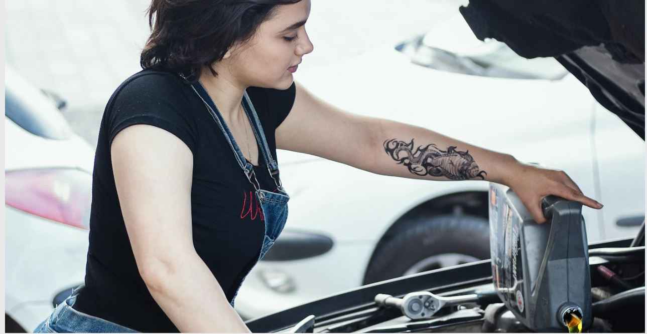 girl is changing oil in car